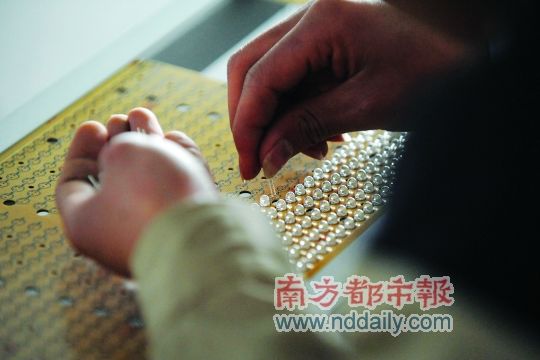 工人忙著安裝用于燈具發(fā)光的LED燈珠，這類工作處于LED燈具生產(chǎn)的最下游。資料圖